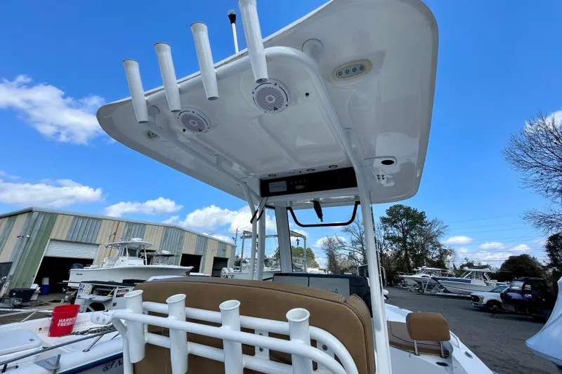 Slide: The Image of 2021 Sea Hunt BX 25 FS boat with T-top and rod holders, parked outdoors. - 25
