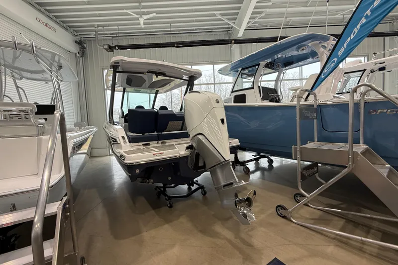 Slide: The Image of 2026 Monterey Elite 25 OB boat in showroom, featuring sleek design and powerful outboard motor. - 11