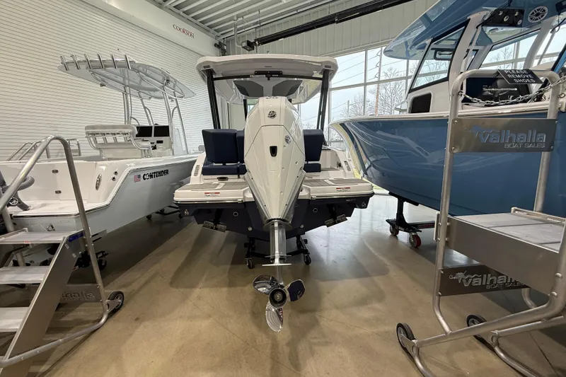 Slide: The Image of 2026 Monterey Elite 25 OB boat displayed in showroom with other boats. - 12