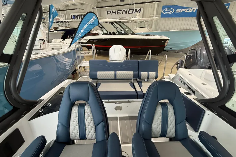 Slide: The Image of 2026 Monterey Elite 25 OB boat interior with blue and white seating in showroom. - 7