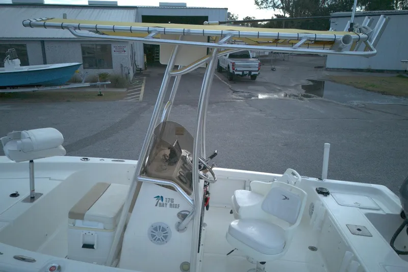 Slide: The Image of 2014 Key West 176 Bay Reef boat with T-top and seating, parked outdoors. - 10
