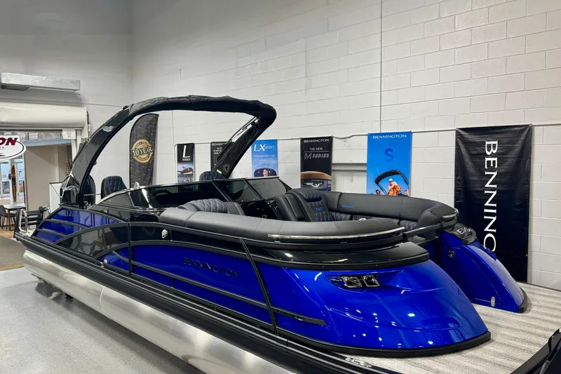 The Image of 2026 Bennington 25 QSBWASE pontoon boat in showroom, featuring sleek blue and black design. - 0