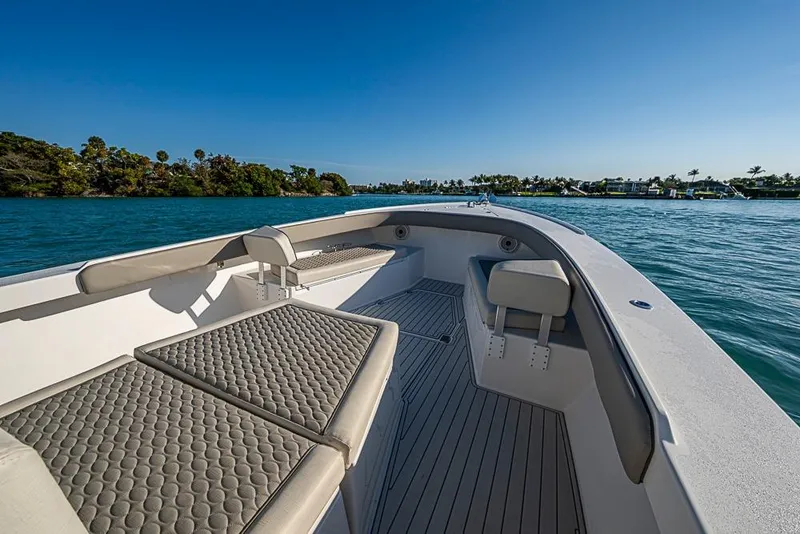 Slide: The Image of 2021 Albury Brothers 33 boat interior with cushioned seating on calm water. - 6