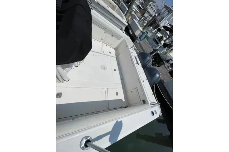 Slide: The Image of 2004 Century 3200 Center Console boat docked, showcasing spacious deck and twin engines. - 14