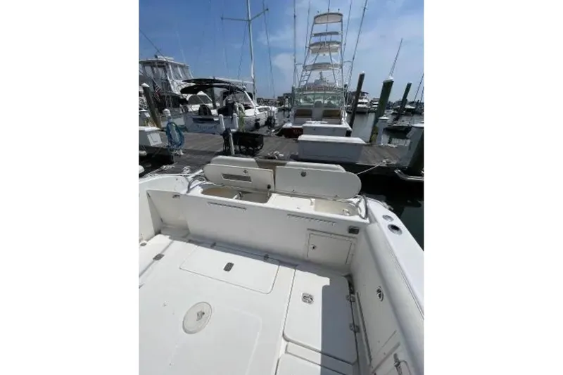 Slide: The Image of 2004 Century 3200 Center Console boat docked at marina, featuring spacious deck area. - 18