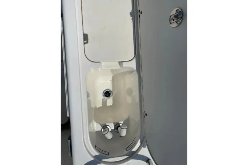 Slide: The Image of 2004 Century 3200 Center Console boat compartment with open hatch and visible fittings. - 19