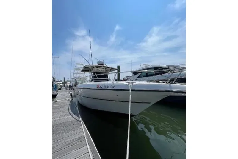 Slide: The Image of 2004 Century 3200 Center Console boat docked at marina under clear blue sky. - 2