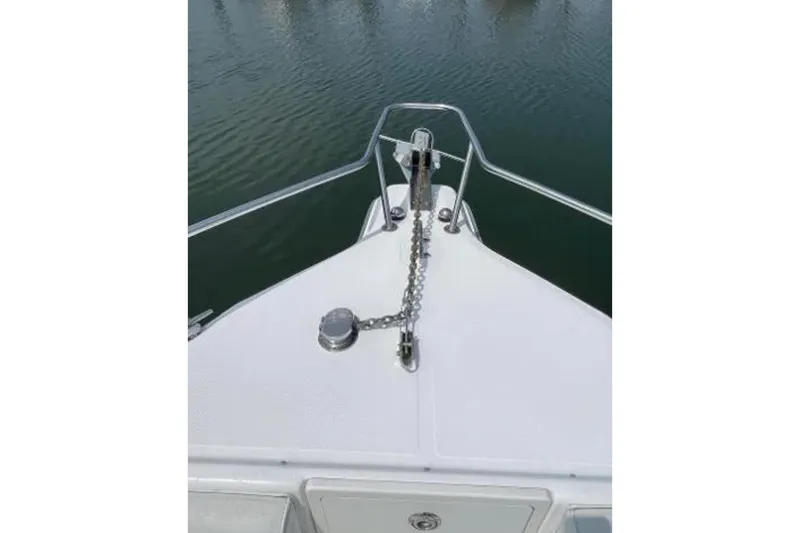 Slide: The Image of Bow of 2004 Century 3200 Center Console boat with anchor chain on calm water. - 39