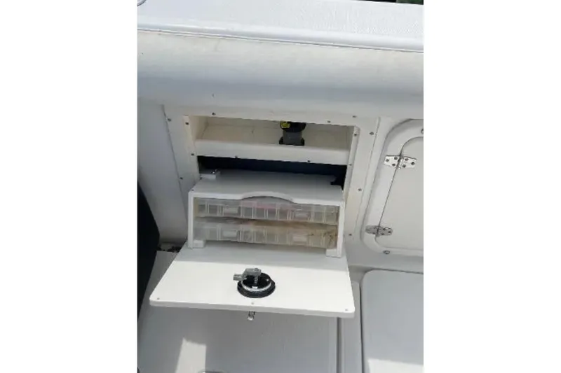 Slide: The Image of Storage compartment on a 2004 Century 3200 Center Console boat with tackle boxes. - 48
