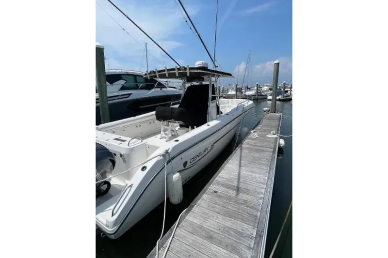 Slide: The Image of 2004 Century 3200 Center Console boat docked at marina under clear blue sky. - 5
