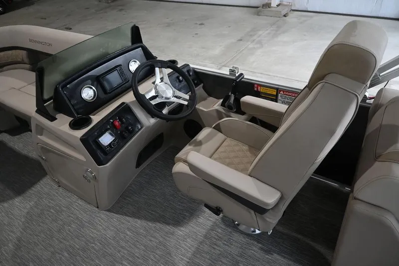 Slide: The Image of 2026 Bennington S Quad Bench 22 SSR boat interior with steering console and seating. - 11