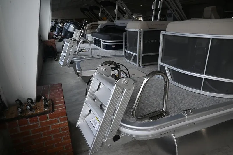 Slide: The Image of 2026 Bennington S Quad Bench 22 SSR pontoon boats in showroom display. - 3