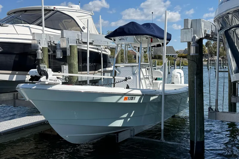 Slide: The Image of 2023 Andros Tarpon 26 boat docked at marina under blue sky. - 11