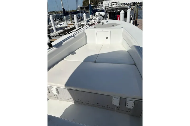 Slide: The Image of 2023 Andros Tarpon 26 boat interior with cushioned seating at dock. - 60
