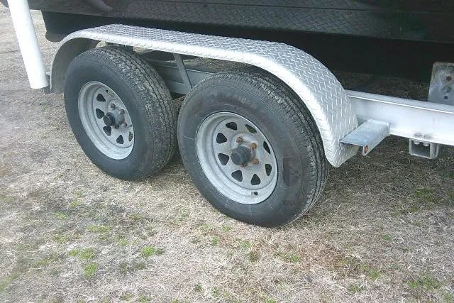 Slide: The Image of Trailer wheels of a 2021 Tidewater 2110 Bay Max boat on grass. - 8