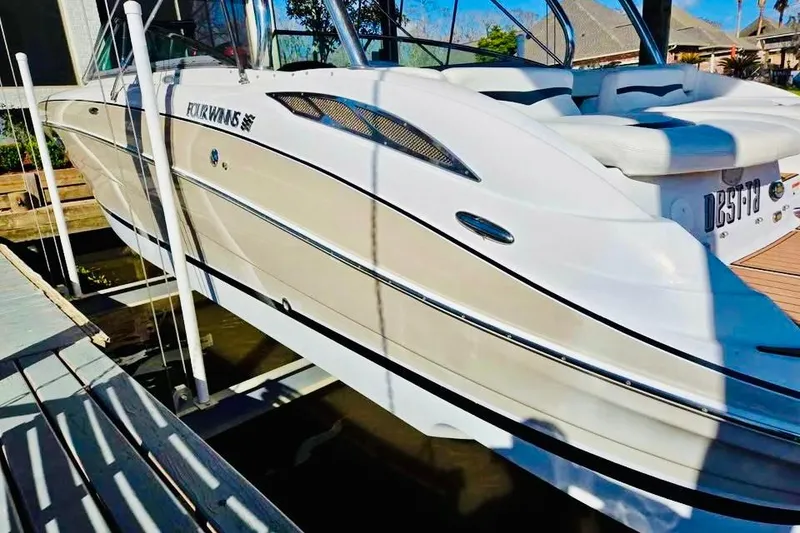 Slide: The Image of 2007 Four Winns 310 Horizon boat docked, showcasing sleek design and white exterior. - 3