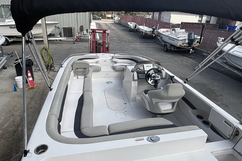 Slide: The Image of 2019 Starcraft MDX 191 O/B boat with spacious seating and modern helm, docked outdoors. - 16