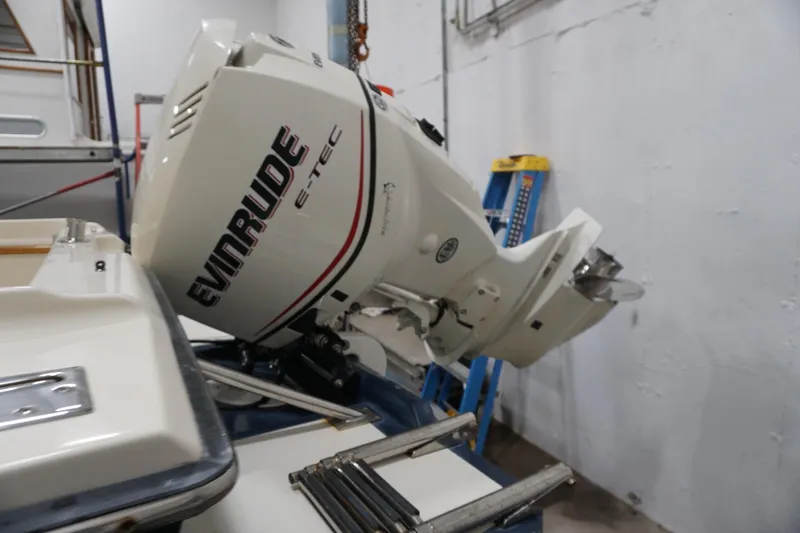 Slide: The Image of 2003 Padebco 23 boat with Evinrude E-TEC outboard motor in a workshop setting. - 19