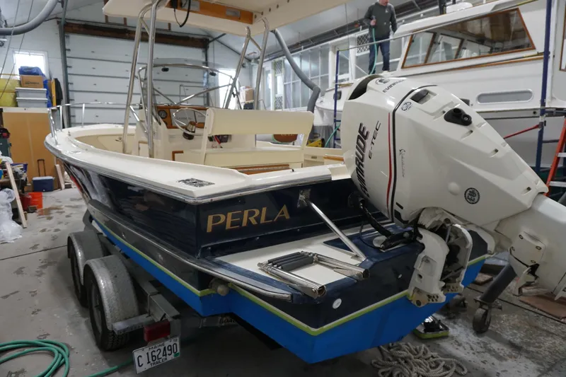 Slide: The Image of 2003 Padebco 23 boat named "Perla" in a garage with Evinrude outboard motor. - 20
