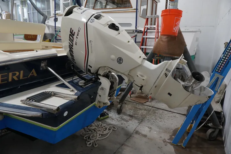 Slide: The Image of 2003 Padebco 23 boat with Evinrude E-TEC outboard motor in a workshop setting. - 21