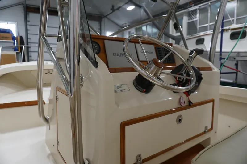 Slide: The Image of 2003 Padebco 23 boat interior with steering wheel and Garmin navigation system. - 29