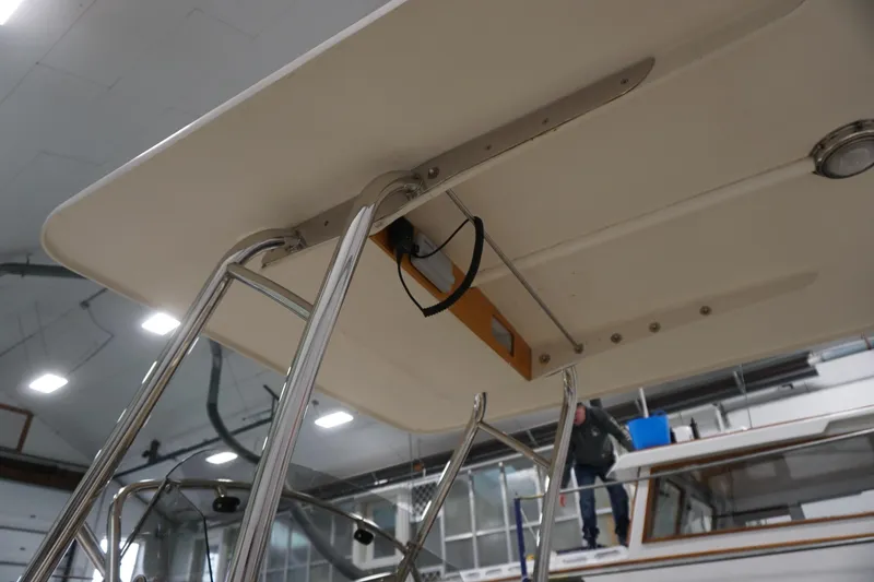 Slide: The Image of 2003 Padebco 23 boat with stainless steel frame and canopy in a workshop setting. - 31