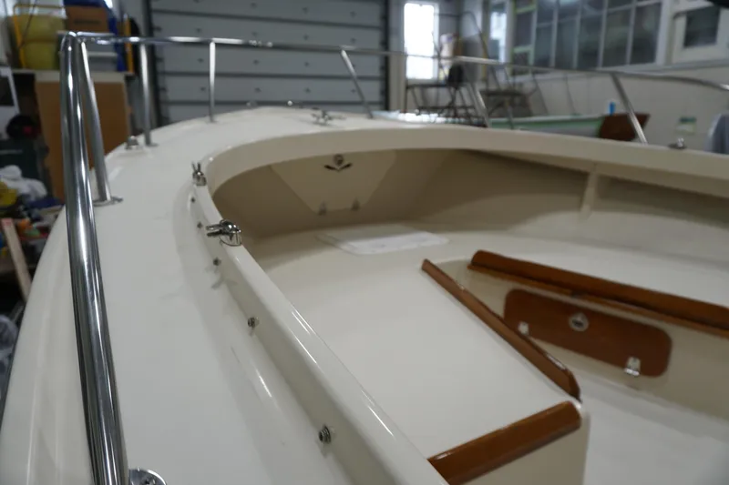 Slide: The Image of 2003 Padebco 23 boat interior with polished wood accents in a garage setting. - 32