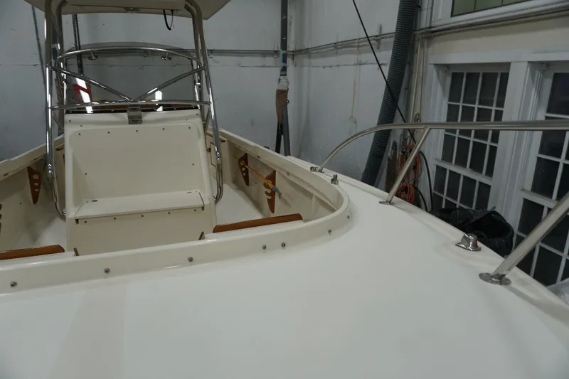 Slide: The Image of 2003 Padebco 23 boat interior with helm and seating in a garage setting. - 35