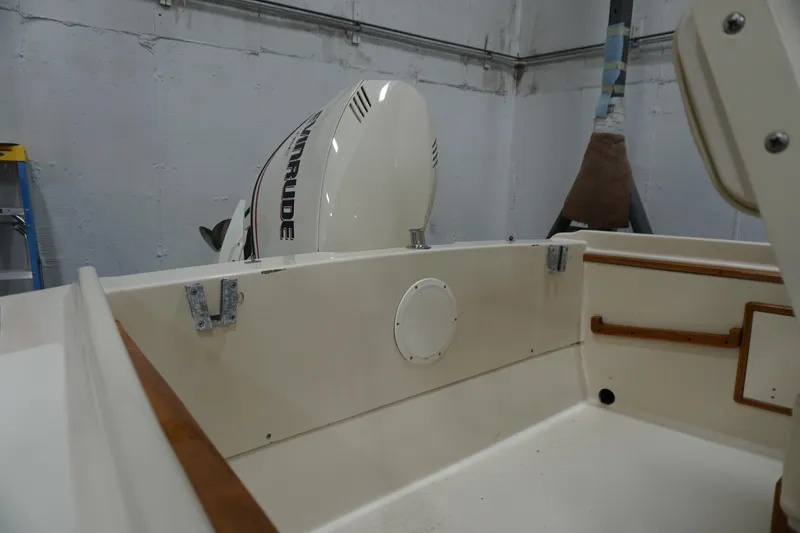 Slide: The Image of 2003 Padebco 23 boat interior with Evinrude outboard motor in a garage. - 40