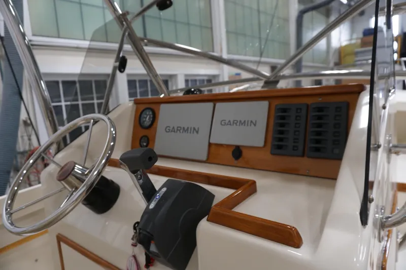 Slide: The Image of 2003 Padebco 23 boat dashboard with Garmin navigation system and steering wheel. - 42