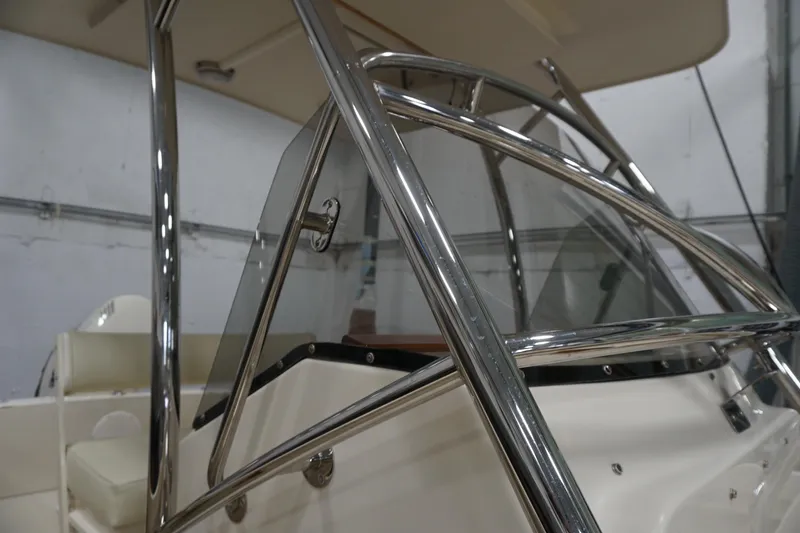 Slide: The Image of 2003 Padebco 23 boat with stainless steel railings and windshield in a showroom. - 43