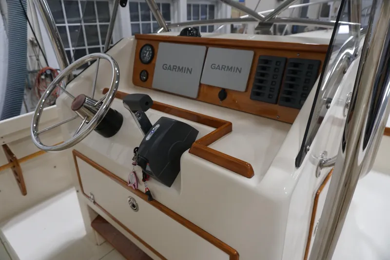 Slide: The Image of 2003 Padebco 23 boat helm with Garmin navigation and wooden accents. - 5