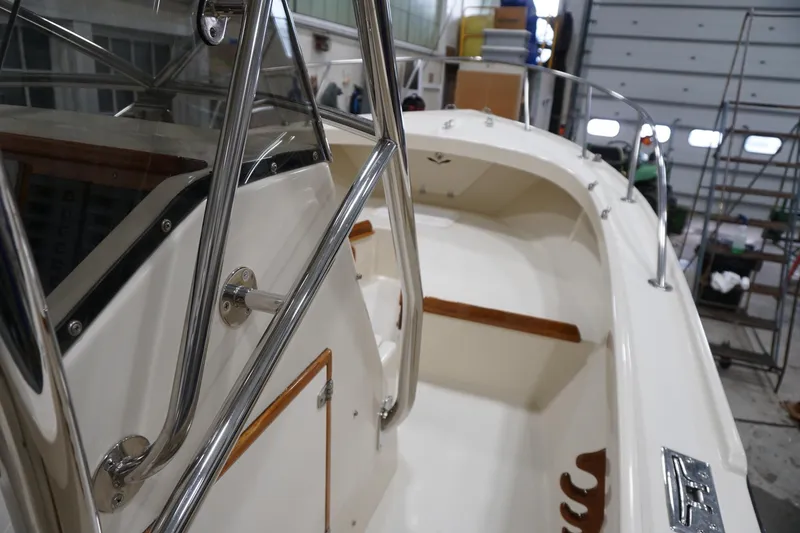 Slide: The Image of 2003 Padebco 23 boat interior with stainless steel railings and wooden accents. - 6