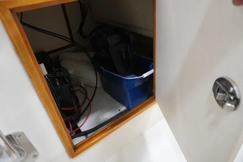Slide: The Image of Open storage compartment on 2003 Padebco 23 boat with equipment and blue container. - 7