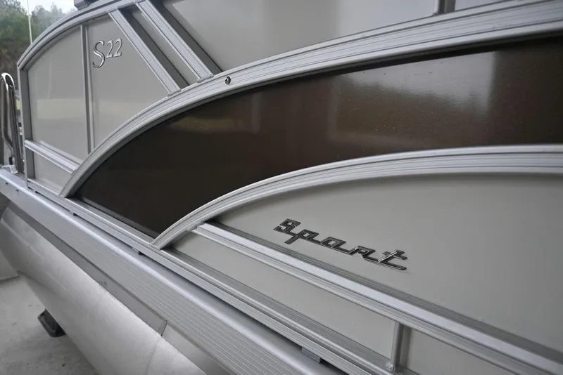 Slide: The Image of 2026 Bennington S Swingback 22 SSB pontoon boat with "Sport" emblem detail. - 2