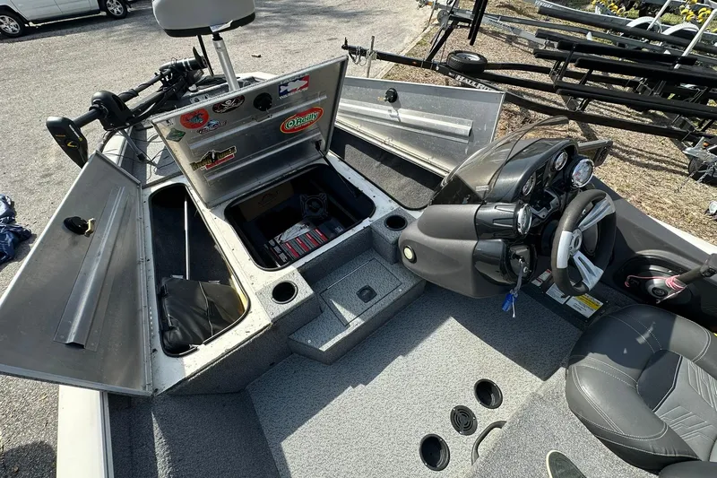 Slide: The Image of 2019 Tracker Pro Team 175 TXW boat interior with open storage compartments and steering console. - 7