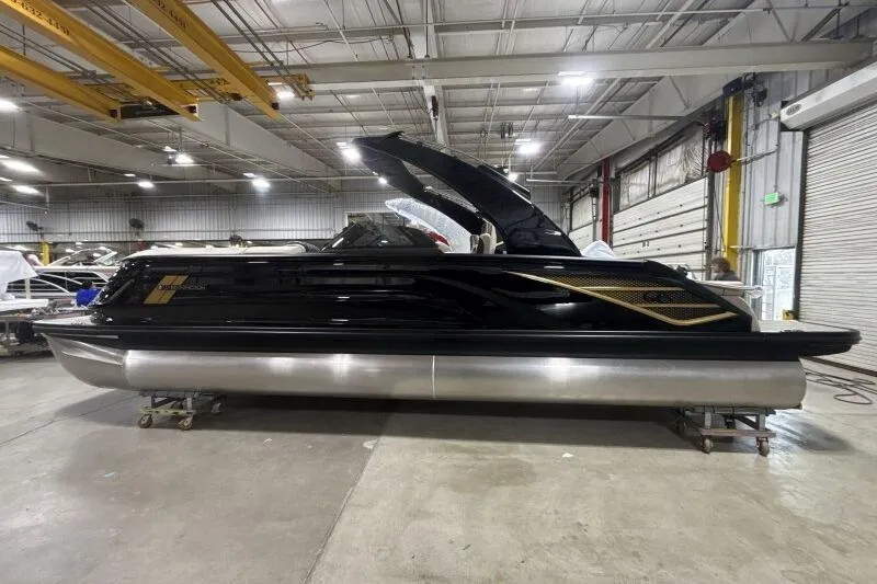 Slide: The Image of 2026 Bennington 25 QXSBWASF pontoon boat in a warehouse setting. - 1