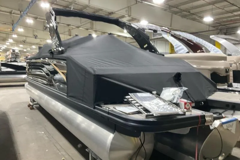Slide: The Image of 2026 Bennington 25 QXSBWASF pontoon boat covered in a warehouse setting. - 22