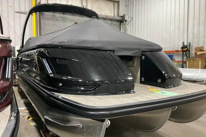 Slide: The Image of 2026 Bennington 25 QXSBWASF pontoon boat with cover in a warehouse setting. - 24