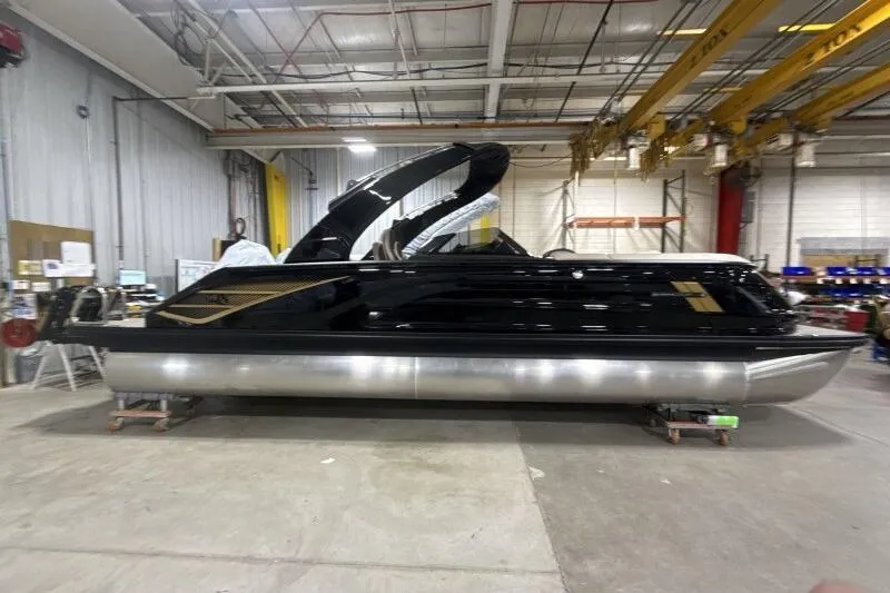 Slide: The Image of 2026 Bennington 25 QXSBWASF pontoon boat in a warehouse setting. - 5