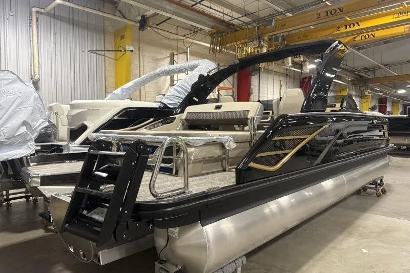 Slide: The Image of 2026 Bennington 25 QXSBWASF pontoon boat in a factory setting, showcasing sleek design. - 6