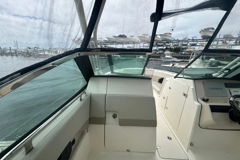 Slide: The Image of 2022 Boston Whaler 240 Vantage boat interior with Garmin navigation, docked at marina. - 23