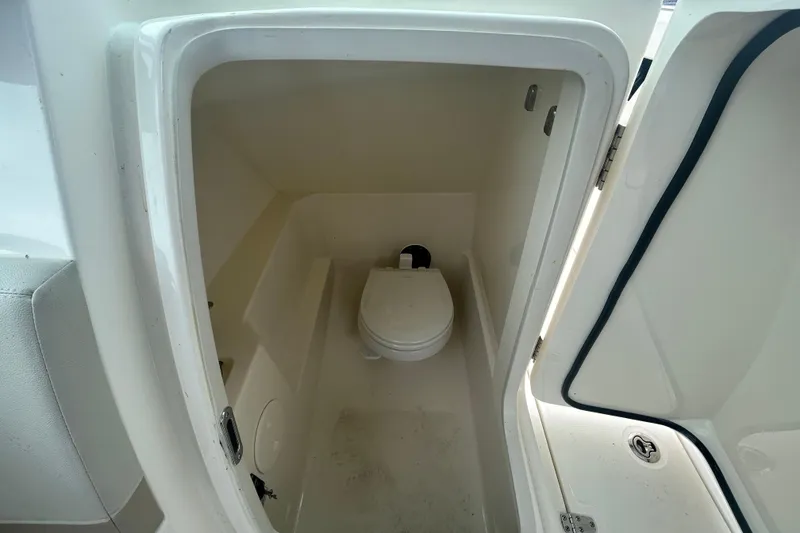 Slide: The Image of 2022 Boston Whaler 240 Vantage boat interior with compact marine toilet. - 24