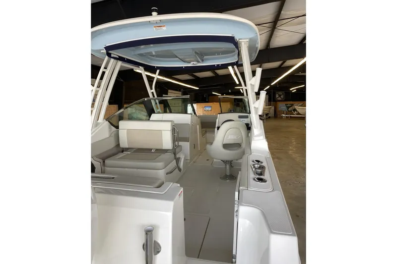 Slide: The Image of 2022 Boston Boatworks Vantage 240 interior with seating and helm in a showroom. - 7