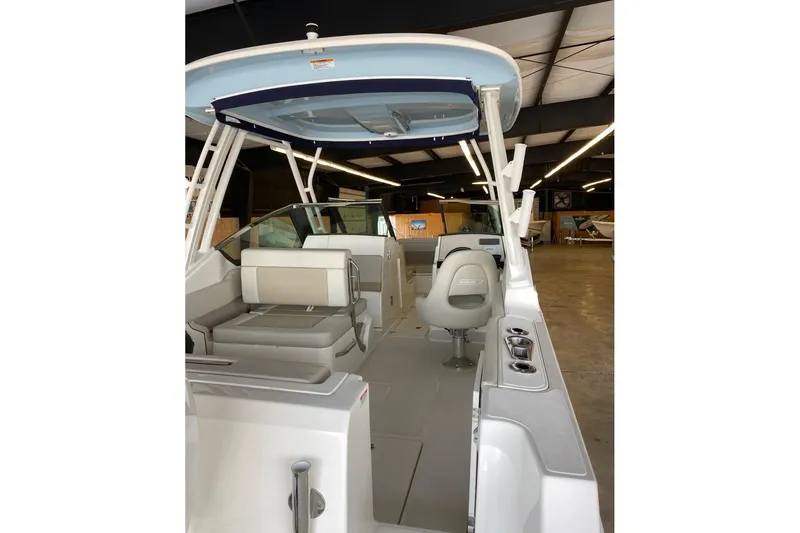 Slide: The Image of 2022 Boston Boatworks Vantage 240 interior with seating and helm in a showroom. - 9