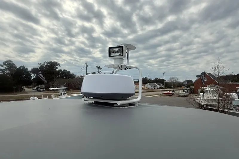 Slide: The Image of 2021 Axopar 28 T-Top boat radar and light against cloudy sky backdrop. - 10