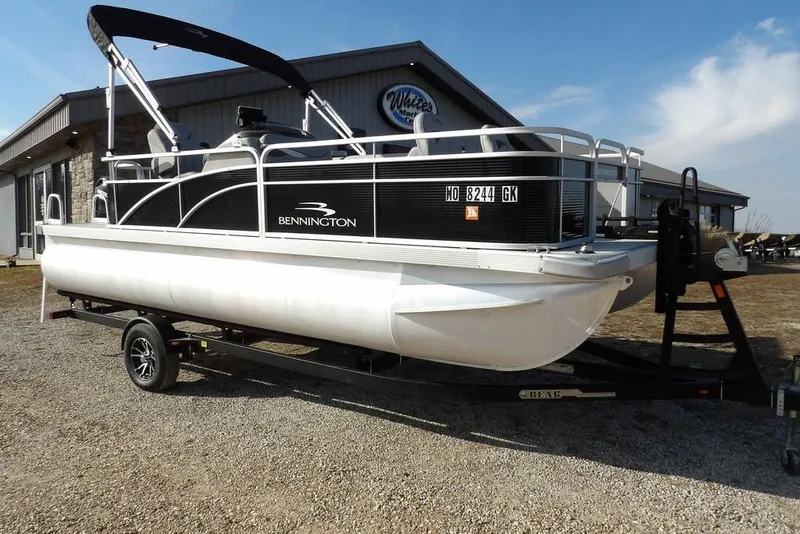 The Image of 2020 Bennington 20 SFV pontoon boat on trailer, parked outside a building. - 1