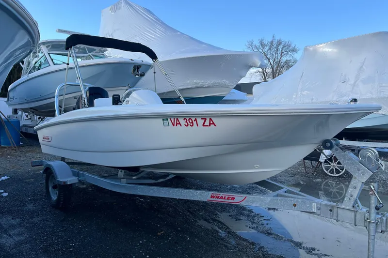 Slide: The Image of 2018 Boston Whaler 170 Super Sport boat on trailer, parked outdoors. - 14