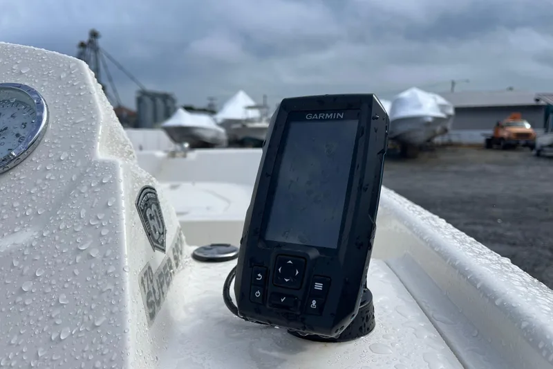 Slide: The Image of 2018 Boston Whaler 170 Super Sport with Garmin device, wet from rain, in a boatyard. - 2