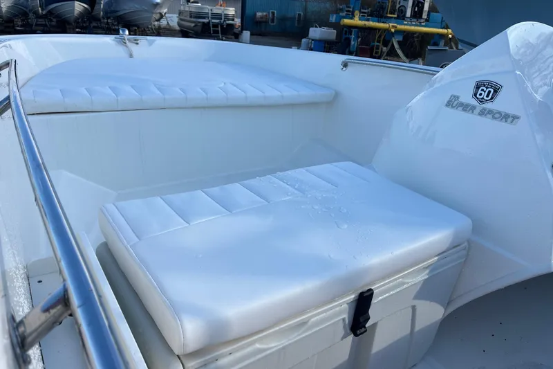 Slide: The Image of 2018 Boston Whaler 170 Super Sport boat interior with white cushioned seating. - 20